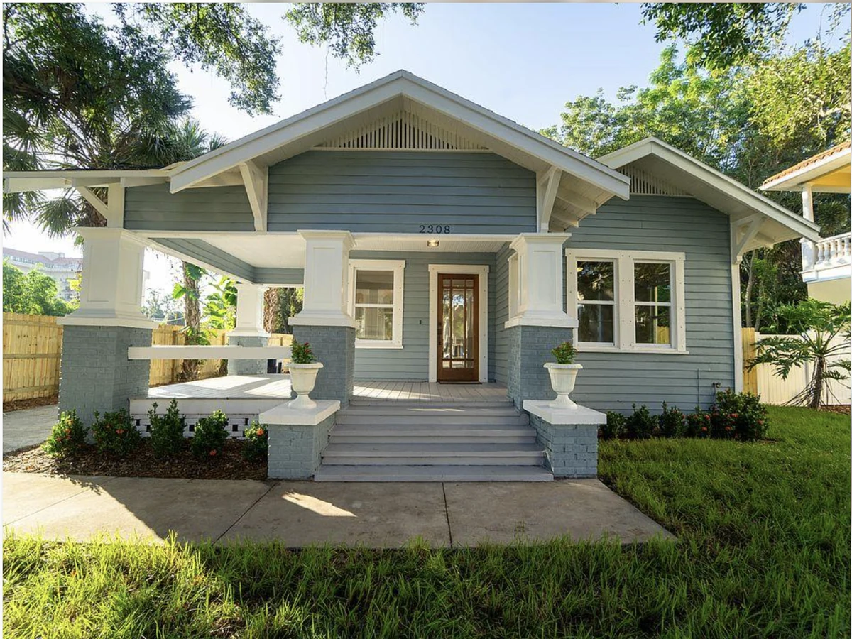 Renovated blue-grey bungalow with a restored front porch and landscaped garden